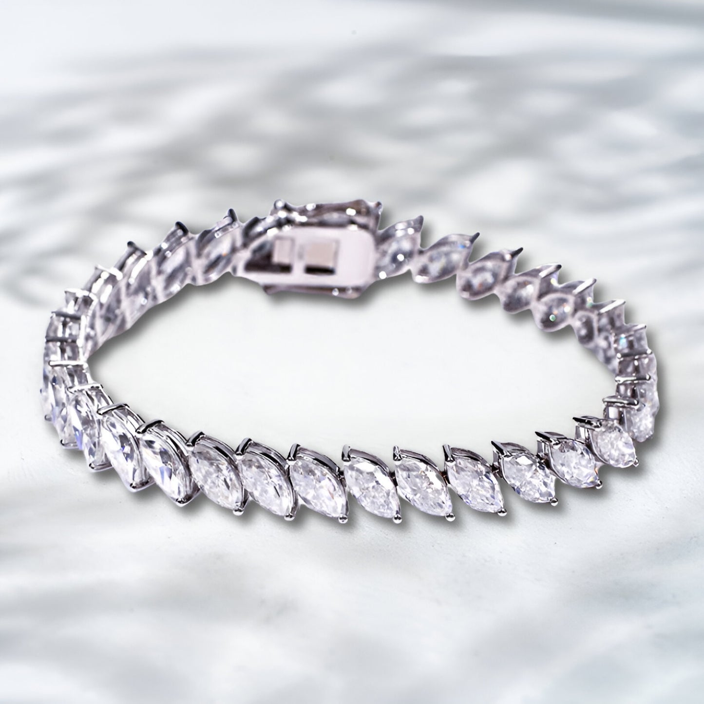 Silver bracelet with clear gemstones on a textured silver background