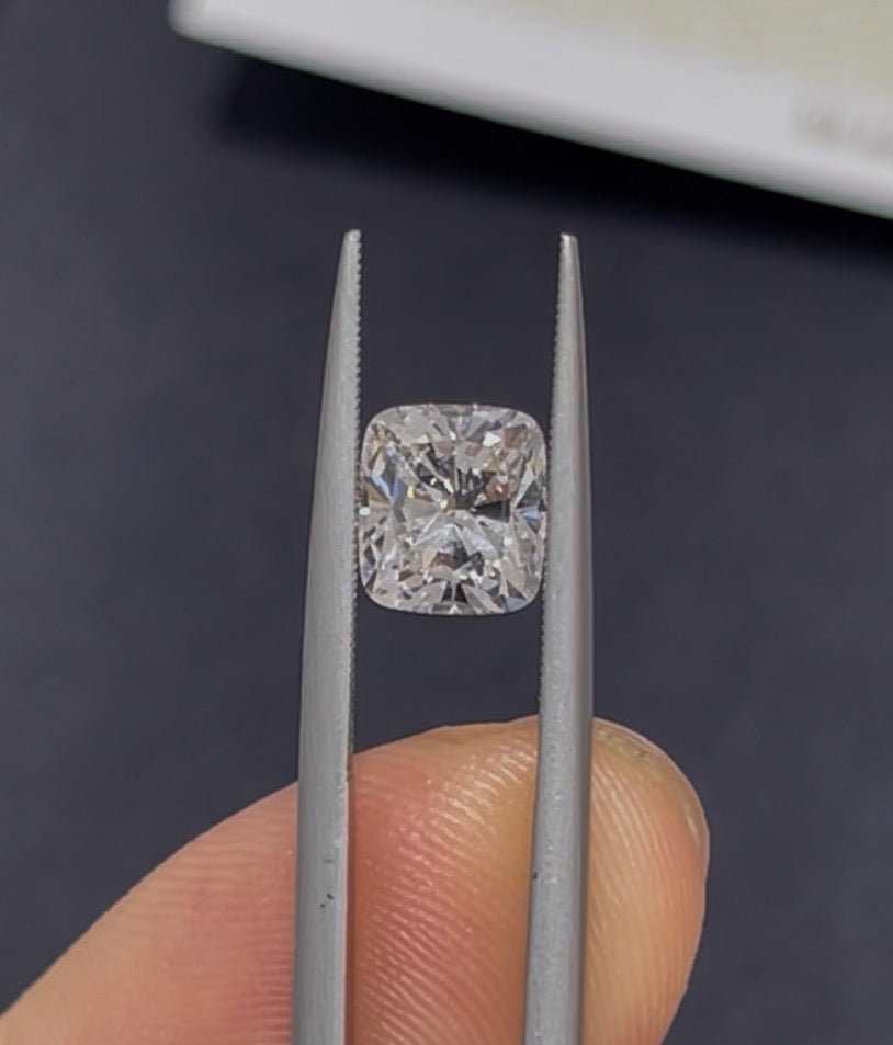 Diamond held between tweezers with a dark background