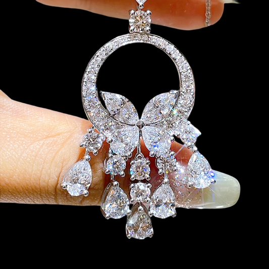 Diamanté butterfly pendant held by a hand against a black background