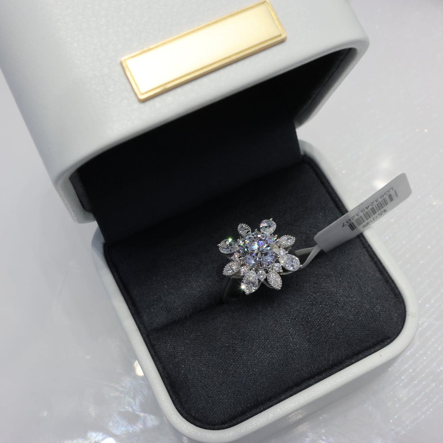 Diamond ring in an open jewelry box with a visible brand tag.