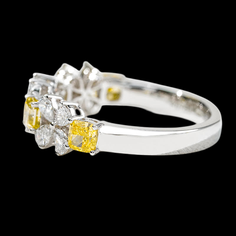 Silver ring with yellow and clear gemstones on a black background