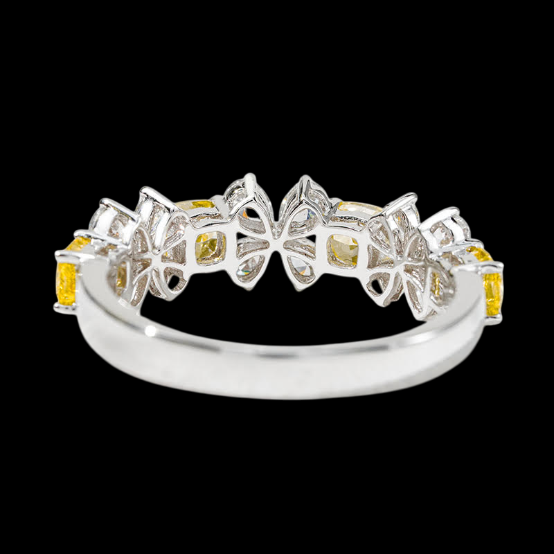 Silver ring with yellow gemstones on a black background