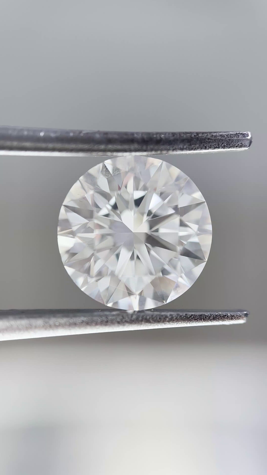 Diamond held between tweezers against a neutral background