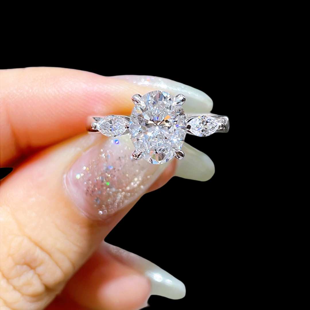 Diamond ring held between fingers against a black background