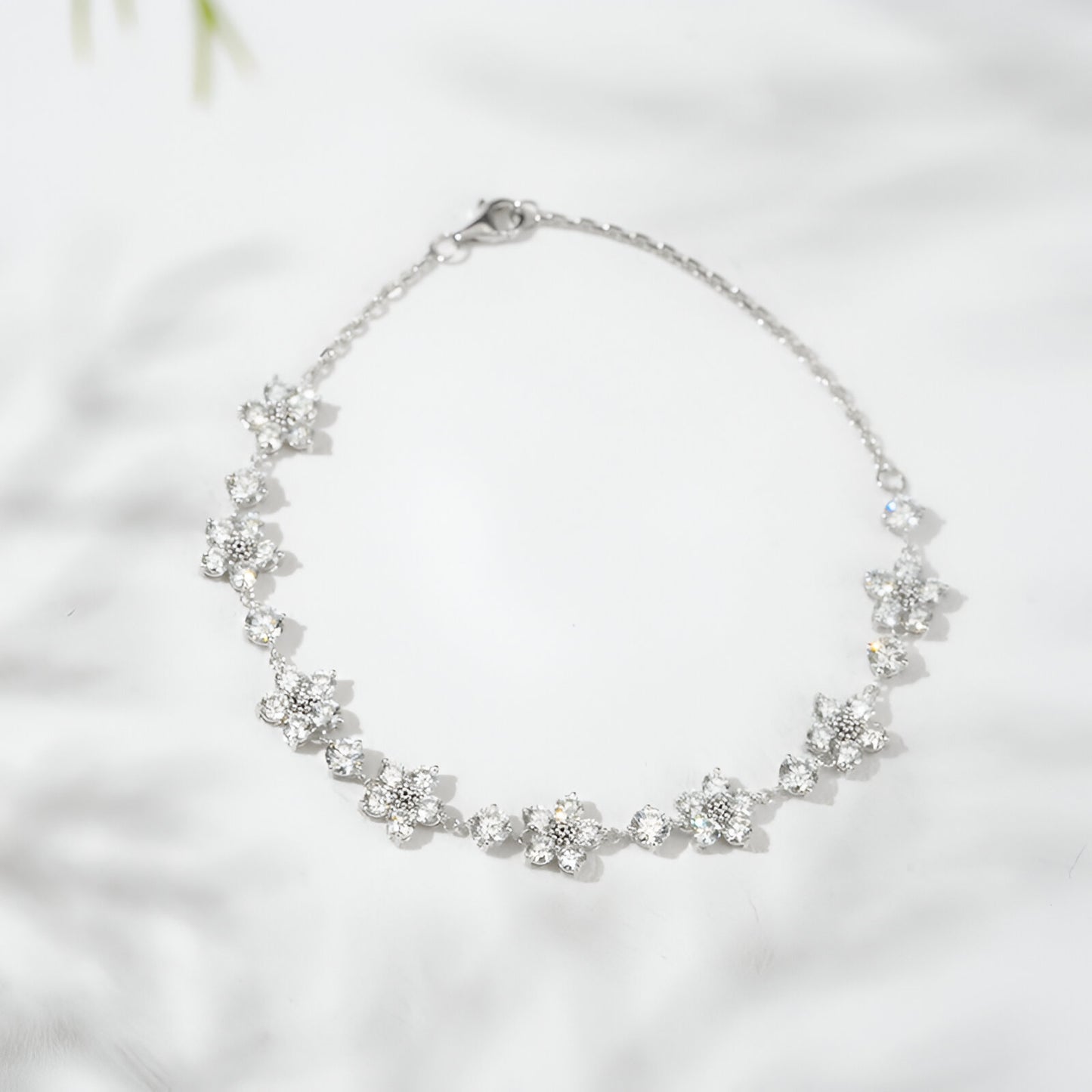 Silver bracelet with floral designs on a light background