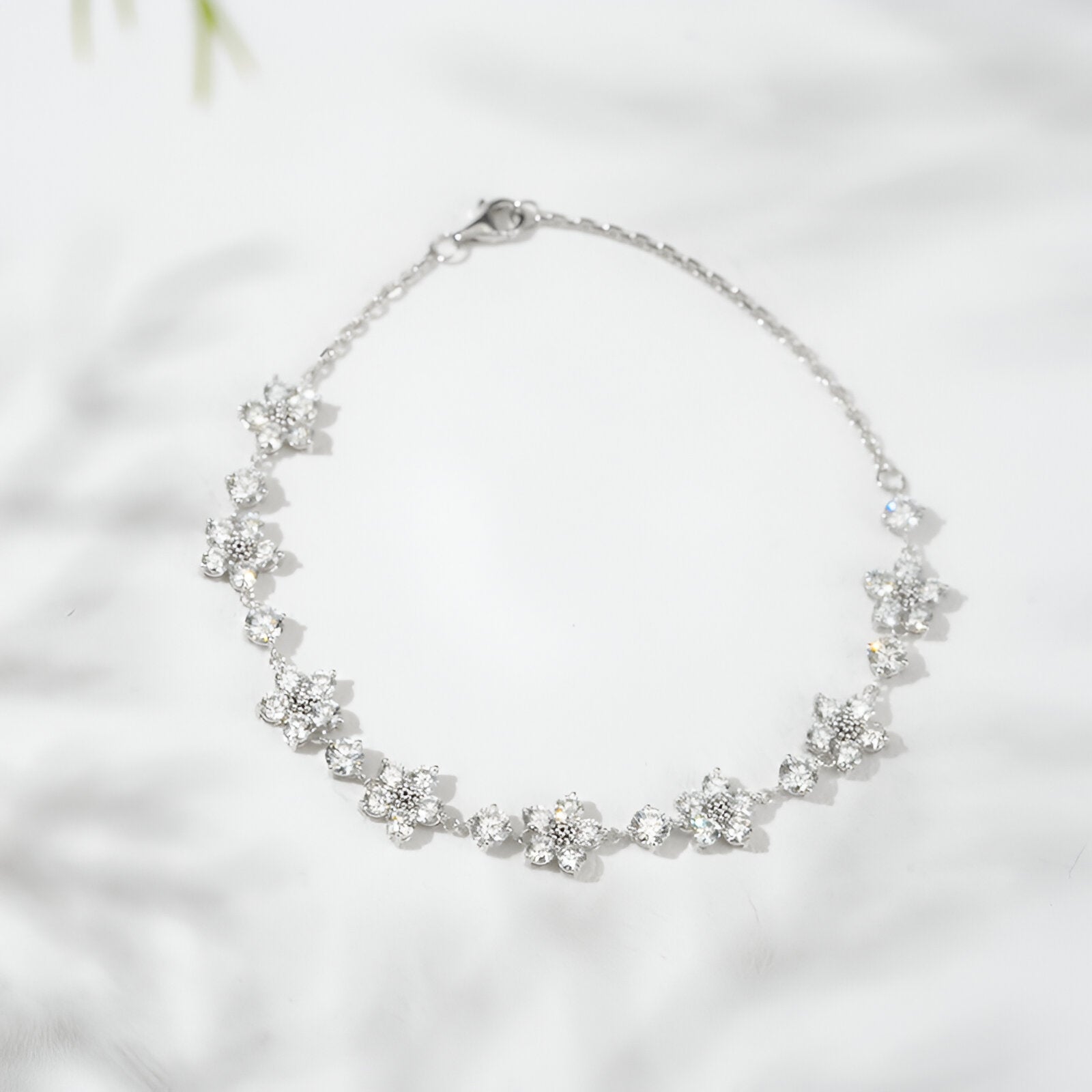 Silver bracelet with floral designs on a light background