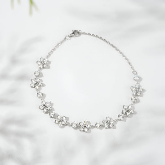 Silver bracelet with floral designs on a light background