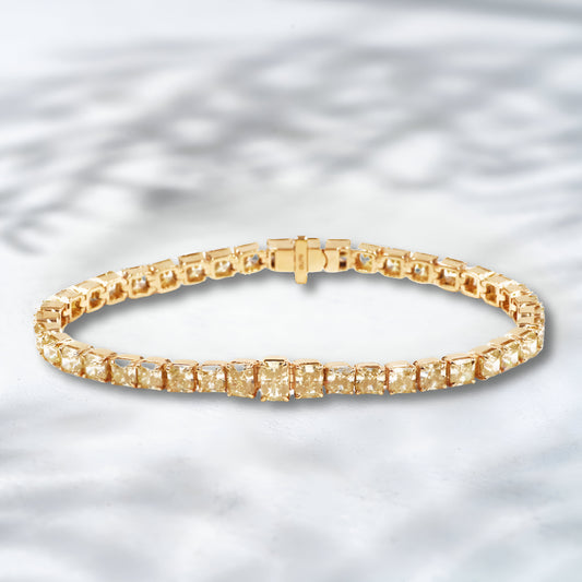 Gold bracelet with square-cut stones on a light gray background