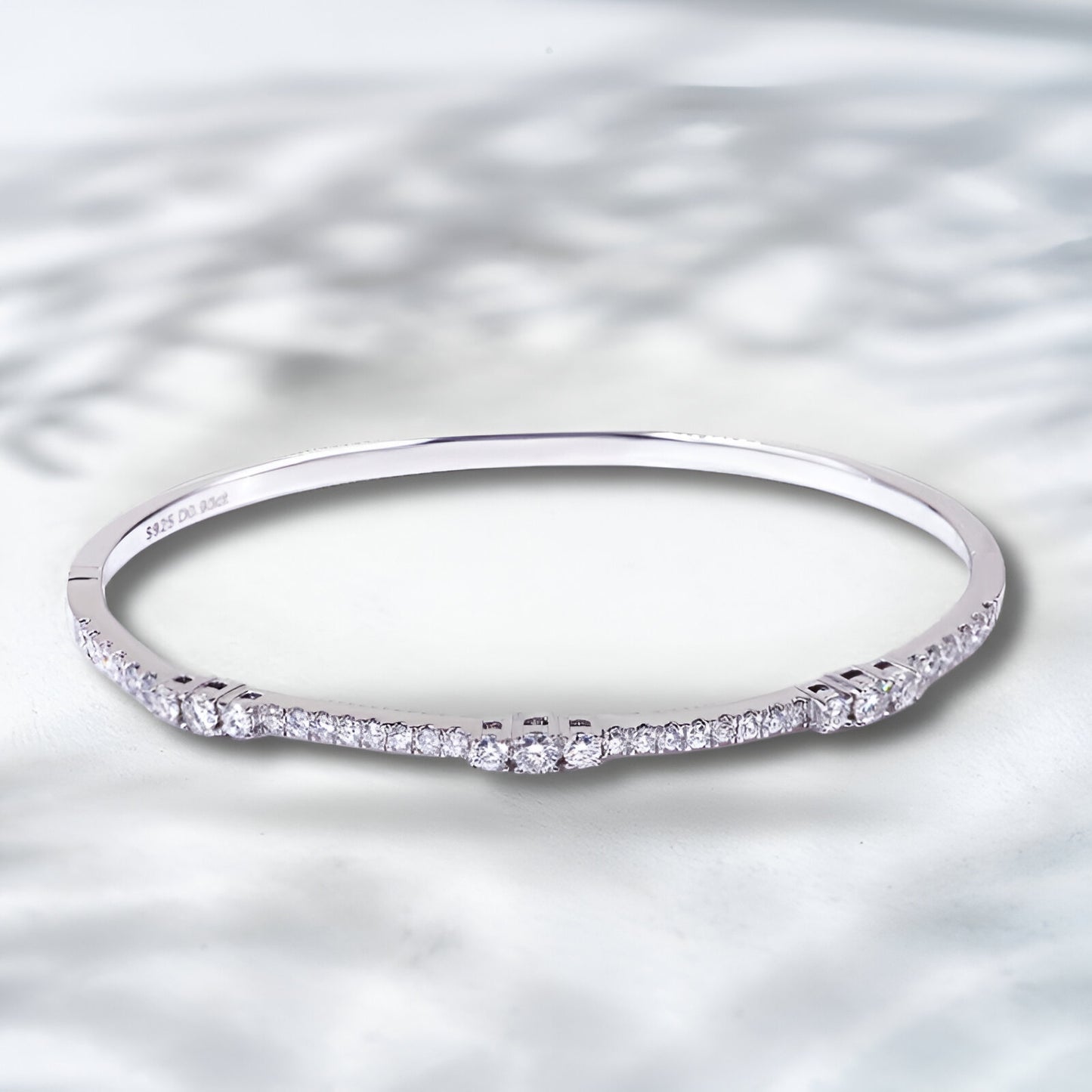 Silver ring with small diamonds on a textured silver background