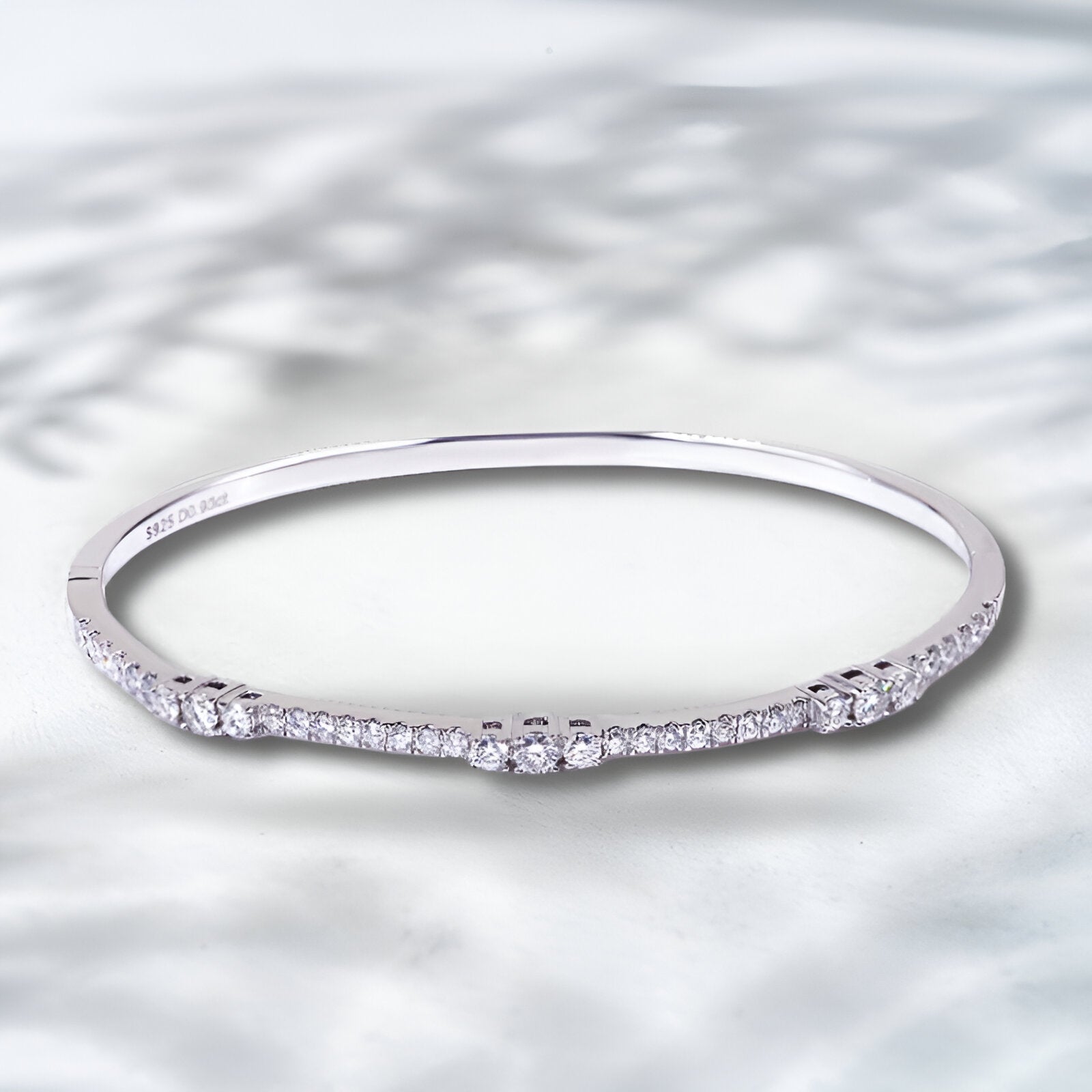Silver ring with small diamonds on a textured silver background