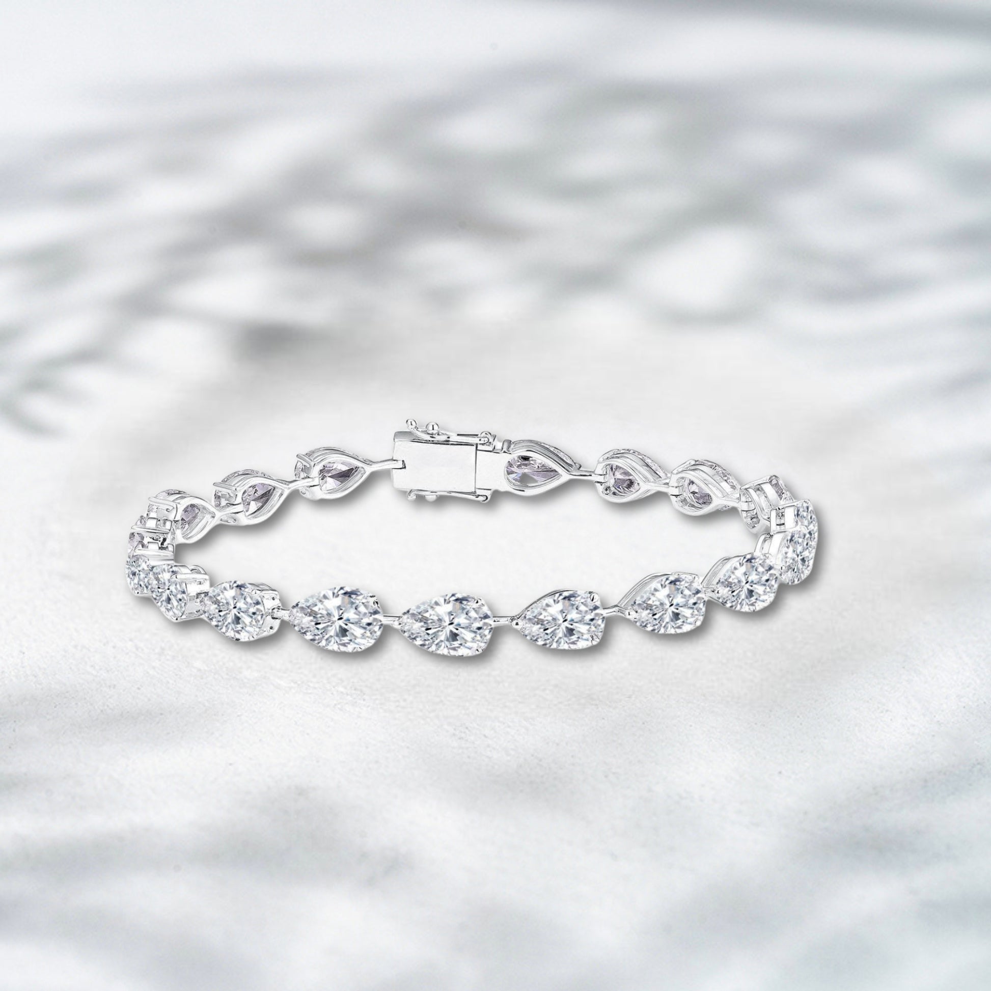 Silver bracelet with a clear clasp on a light gray background