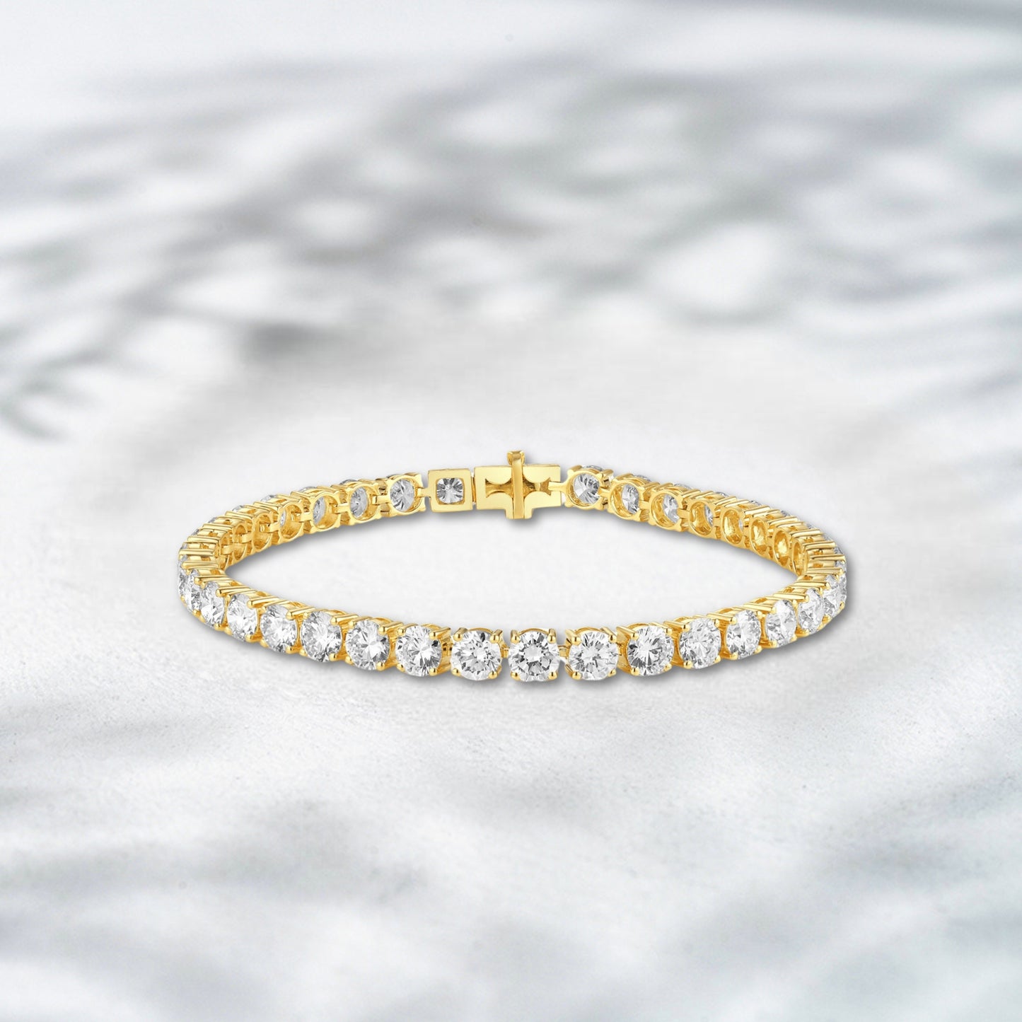 Gold bracelet with diamonds on a textured gray background