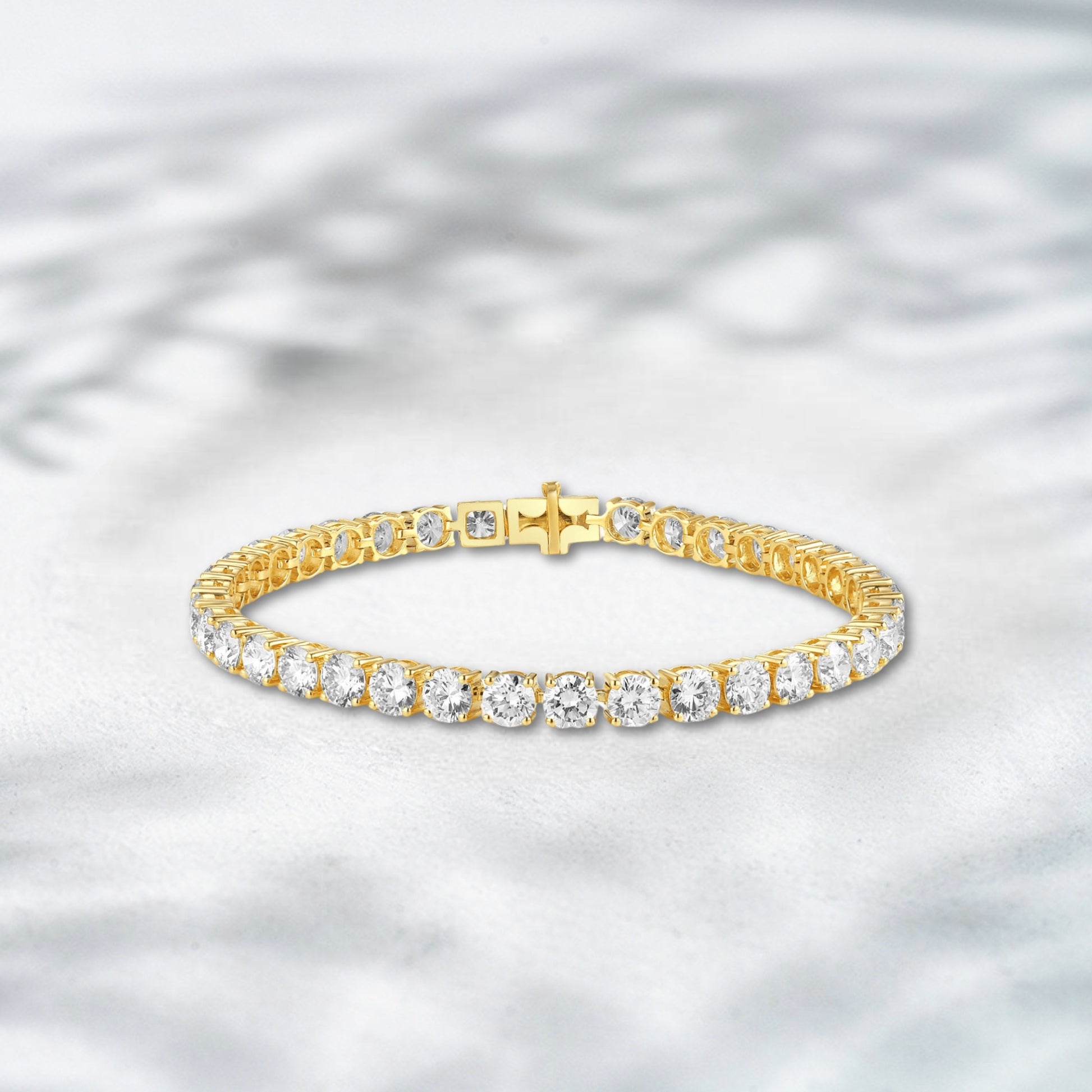 Gold bracelet with diamonds on a textured gray background