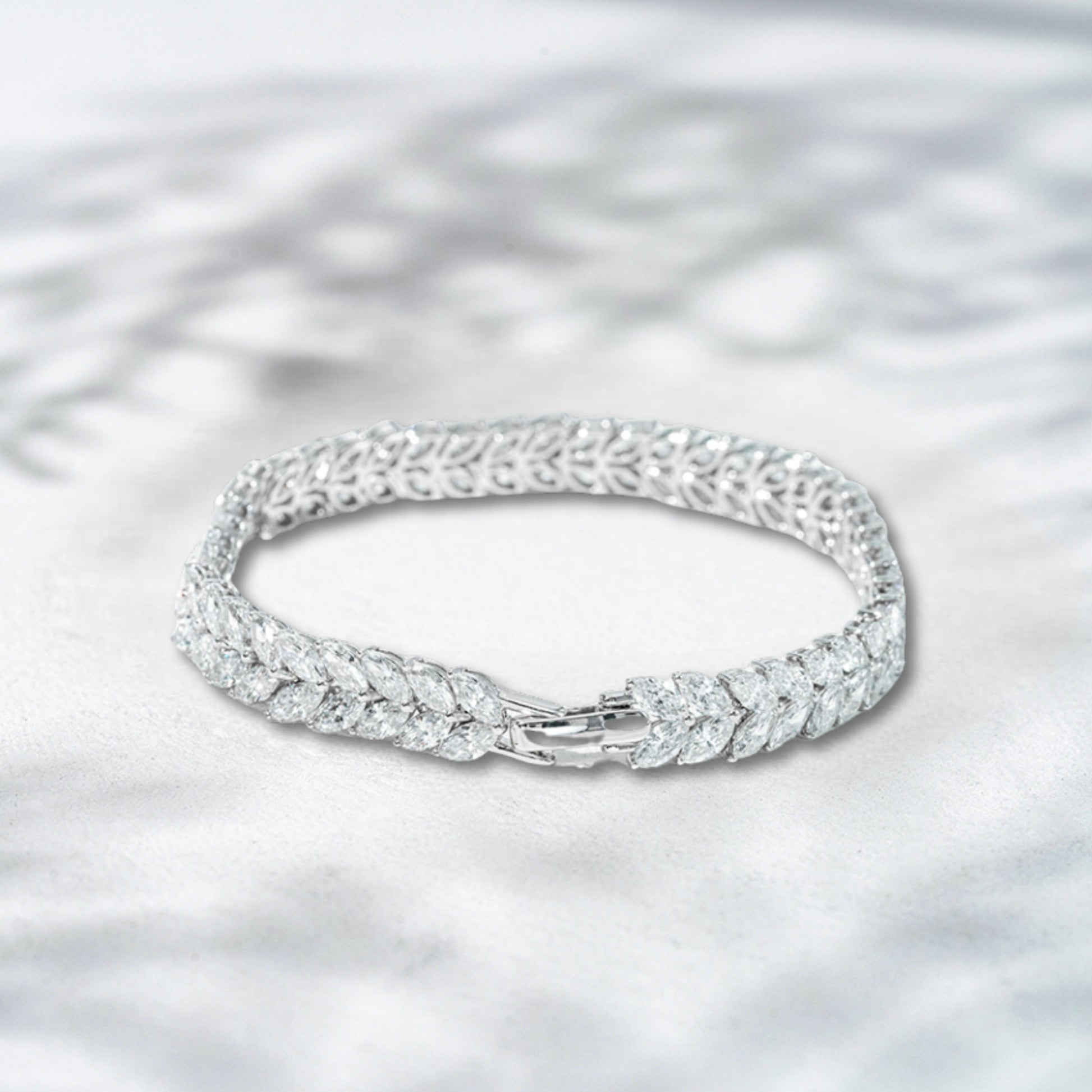 Silver bracelet with intricate design on a light gray background