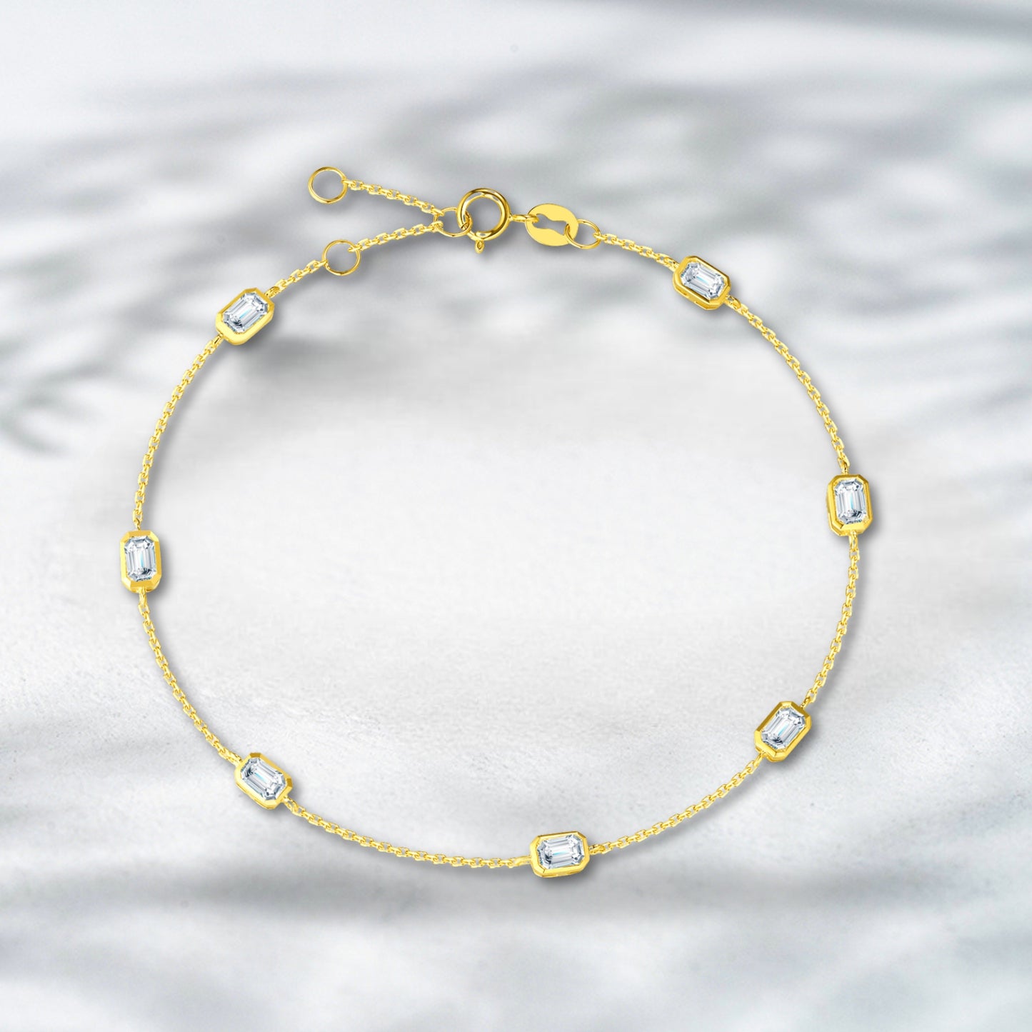 Gold bracelet with diamond-like stones on a textured silver background