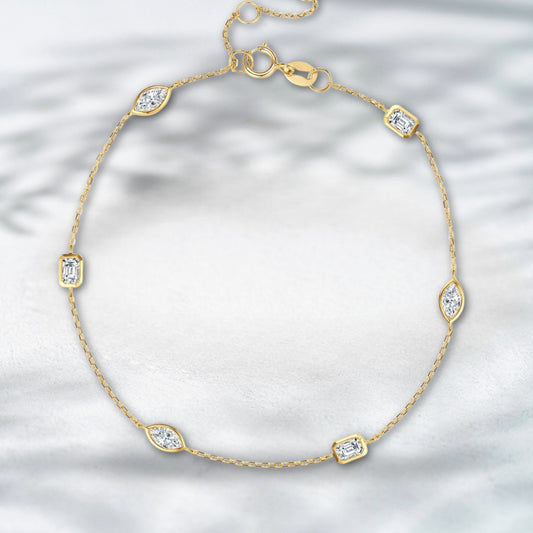 Gold bracelet with diamond accents on a light gray background