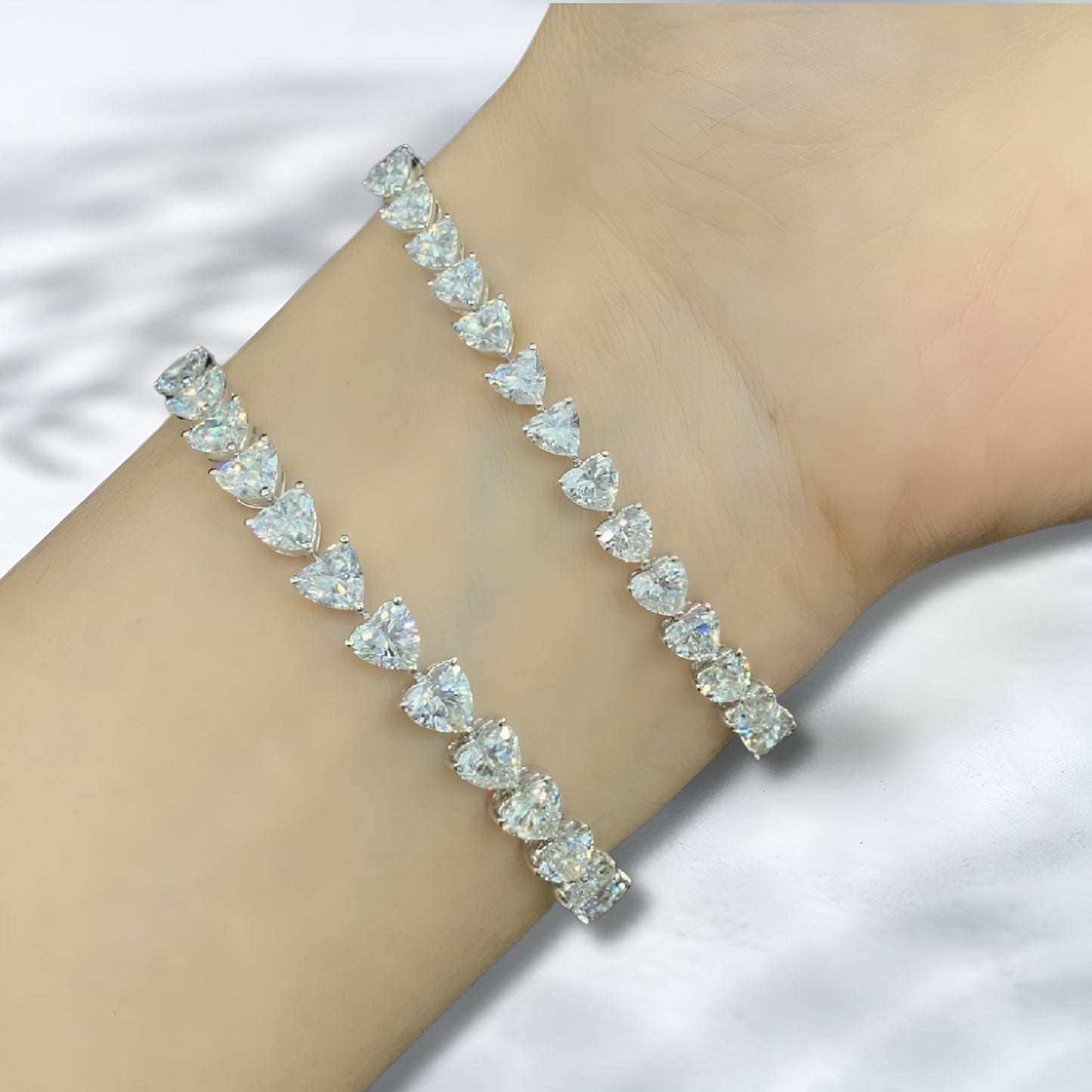 Silver bracelet with clear gemstones on a wrist against a white background