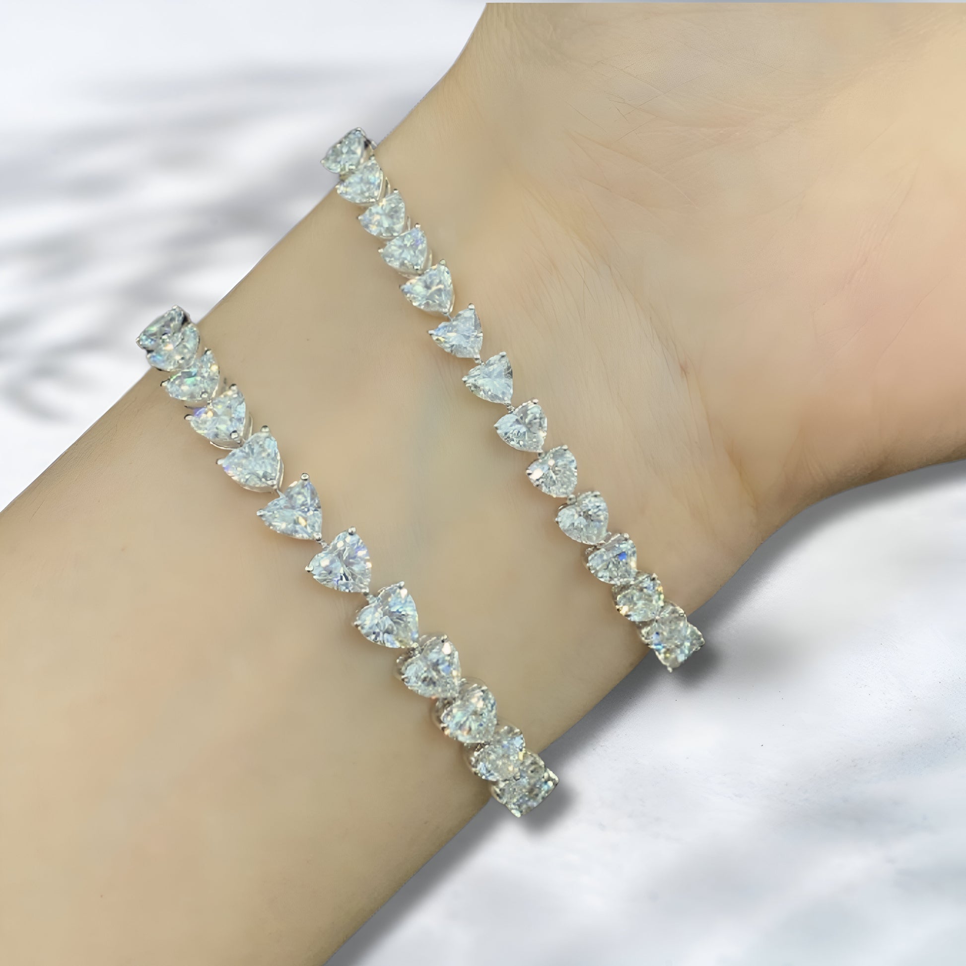 Silver bracelet with clear gemstones on a wrist against a white background