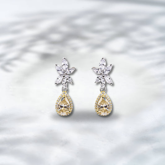 Pair of teardrop-shaped earrings with diamond accents on a light background